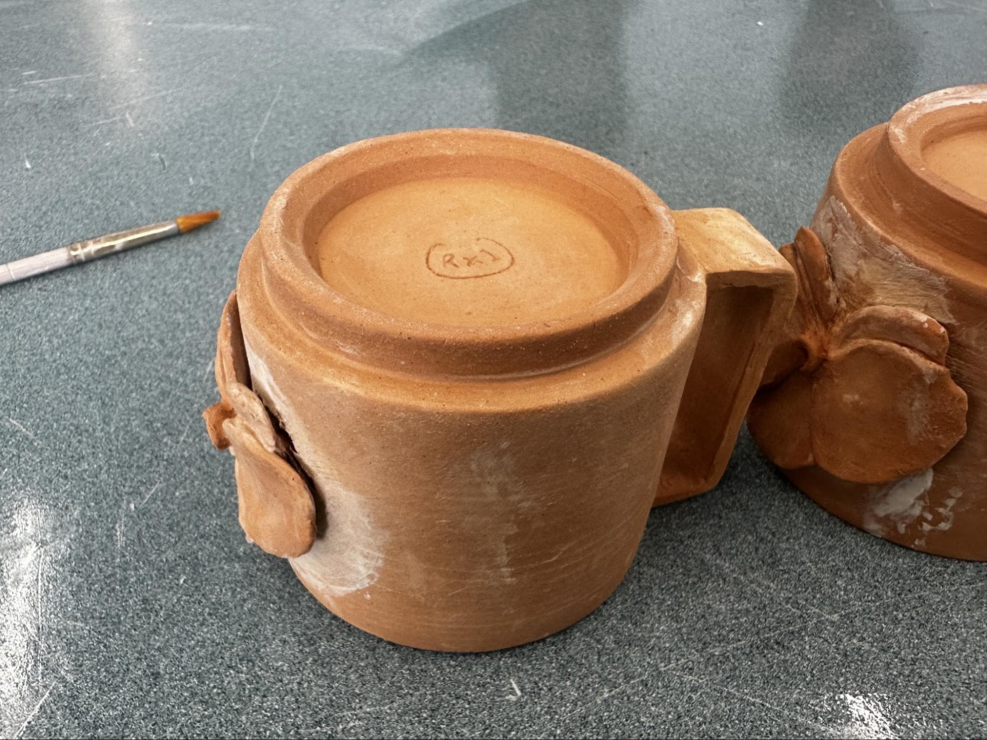 Doubled Orchid Cups · sketch → bisqueware → glazed → glazeware · trimmed to fit · Handbuilt floral and handle — Ceramic work by RuiXuan Xu — School
